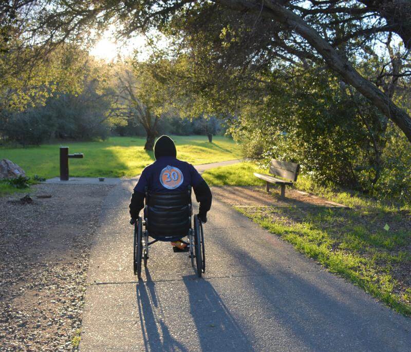 Trail user with wheelchair on wheelchair-friendly trail